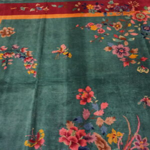 Teal plush rug with large colorful floral sprays and butterflies, bordered in magenta and gold.