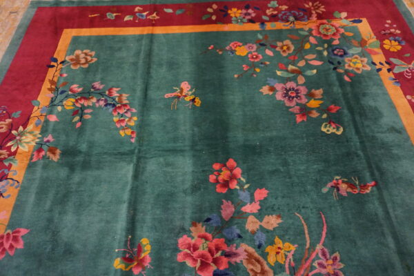 Teal plush rug with large colorful floral sprays and butterflies, bordered in magenta and gold.