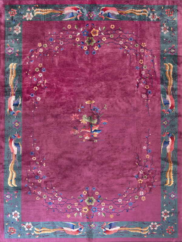 Magenta rug with a blue-green border patterned with colorful birds and a central floral medallion.