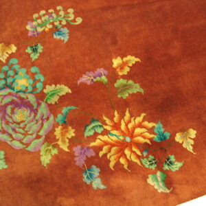 High-pile reddish-brown rug with colorful floral motifs and white fringe visible at the corner.