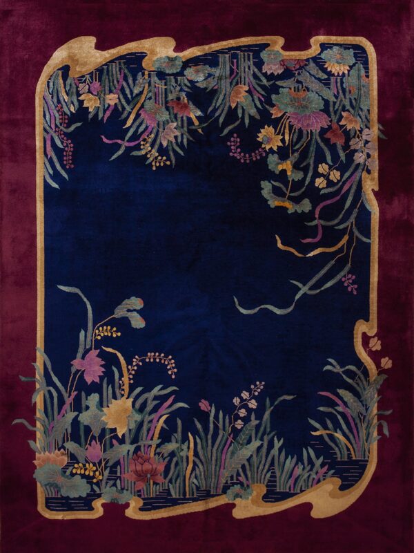 Plush navy rug with a burgundy border, intricately patterned with stylized reeds, leaves, and flowers.