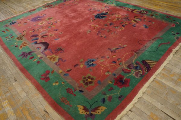 Rose and multicolored floral rug featuring wide green and brown borders on distressed wood planks.