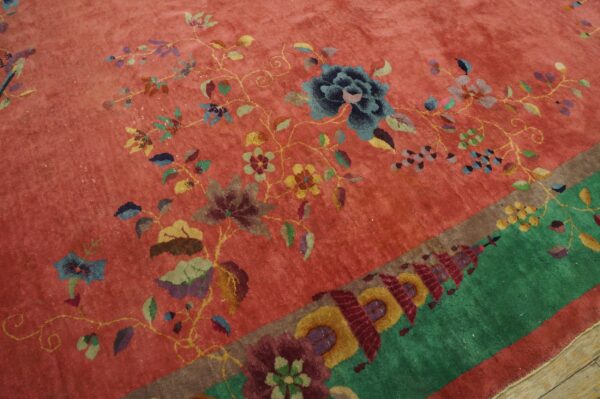 High-pile rug featuring a pink field with colorful floral vines and a contrasting green geometric border.