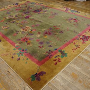 Plush green rug with abundant pink and purple florals, bordered by magenta and gold, resting on rustic wood floors.