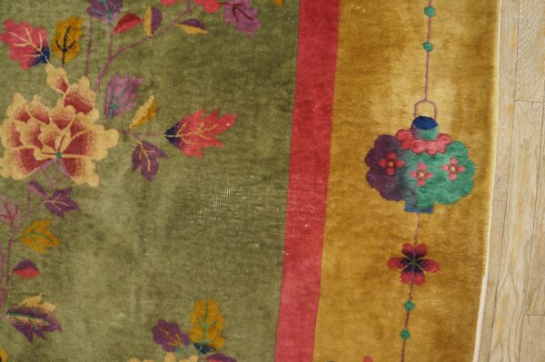 Green and gold high-pile rug with colorful floral and lantern patterns rests on wood floorboards.