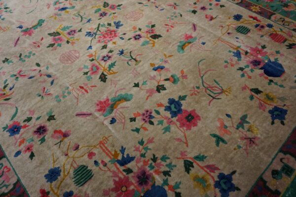 Plush beige rug with a dense multi-color floral and vine pattern extending into the border.