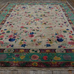 Beige rug featuring detailed pink and blue floral motifs and birds, framed by thick teal and burgundy borders.