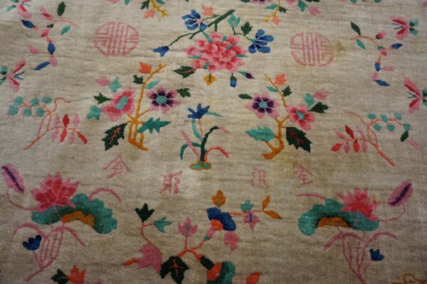 Close up of a plush cream rug with bright pink and blue botanical patterns and pink symbols.