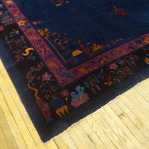 Corner view of a navy rug featuring purple, black, and multicolored borders on light wooden flooring.
