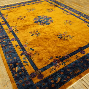 Vibrant gold high-pile rug featuring a complex blue border and colorful floral patterns on wood floors.