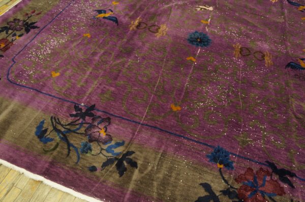 Decorative low-pile purple rug featuring detailed floral and bird motifs bordered in dark brown on wood flooring.