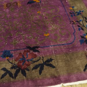 Distressed purple rug featuring a brown border decorated with large blue and maroon stylized floral vines.
