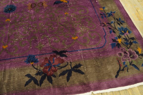 Distressed purple rug featuring a brown border decorated with large blue and maroon stylized floral vines.