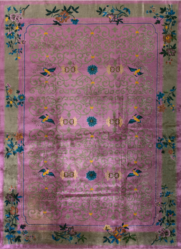 Shimmering magenta rug displaying scrolling green patterns and colorful floral and bird motifs on a green border.