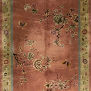 Rust field rug featuring winding floral branches and butterflies, framed by green and slate blue borders.