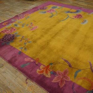 Golden-yellow rug with a wide purple border and colorful floral pattern on aged wood planks.