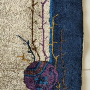 High-pile rug texture showing abstract branches and a purple circle motif on beige and navy fields.