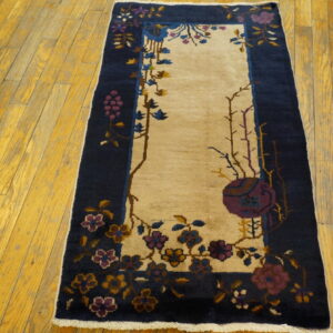 A navy and cream runner rug with purple, blue, and gold floral patterns rests on yellow hardwood.