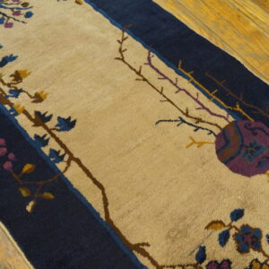 Navy and beige runner rug on wood floor with purple, blue, and yellow floral vine details.