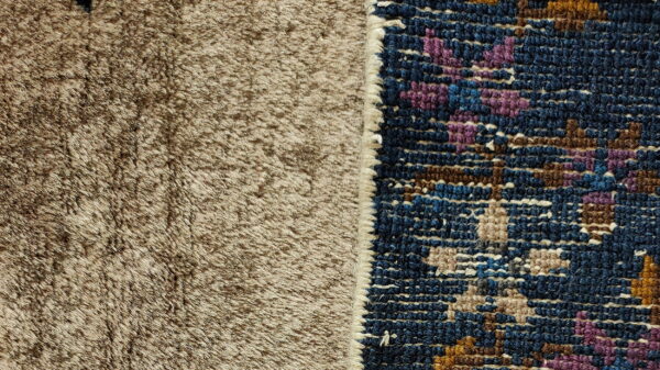 Close-up of a brown shaggy rug texture beside a patterned navy rug edge with purple and brown accents.