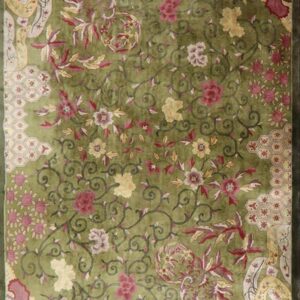 Vibrant lime green rug featuring an all-over design of scrolling vines, red flowers, and patterned corner panels.