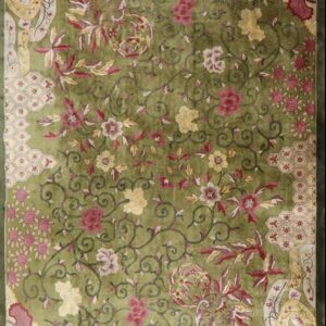Vibrant lime green rug featuring an all-over design of scrolling vines, red flowers, and patterned corner panels.