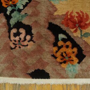 Floral motifs in orange and red stand out against black and brown zigzag patterns on a wood floor.