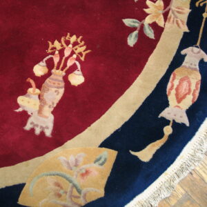 High-pile red and navy blue rug featuring elaborate floral and lantern motifs on a wood floor.
