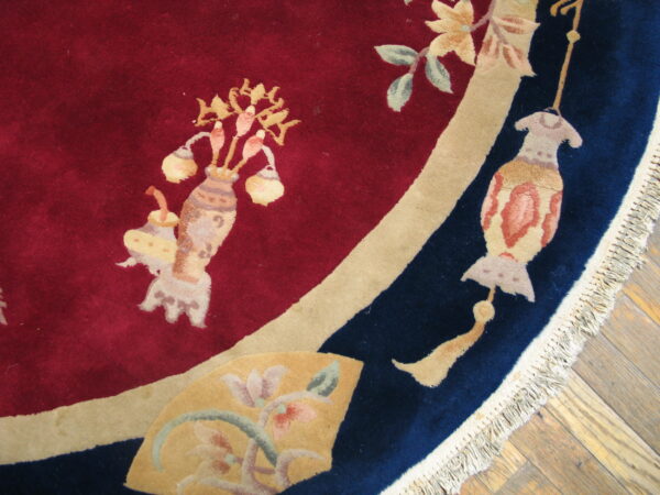 High-pile red and navy blue rug featuring elaborate floral and lantern motifs on a wood floor.