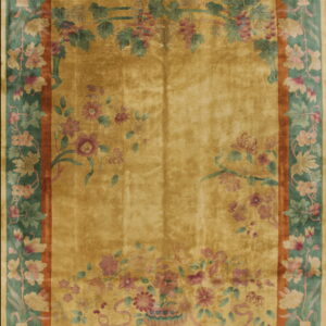 High sheen golden rug featuring an ornate teal and rust border with detailed floral and vine motifs.