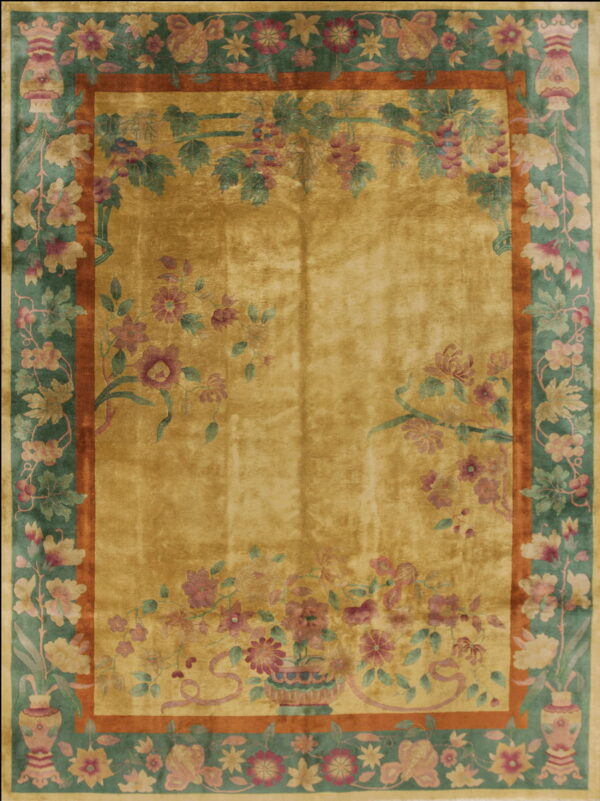 High sheen golden rug featuring an ornate teal and rust border with detailed floral and vine motifs.