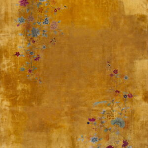 Golden yellow rug featuring trailing pink, blue, and green floral branches across a low pile field.