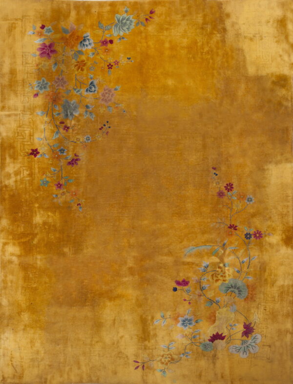 Golden yellow rug featuring trailing pink, blue, and green floral branches across a low pile field.