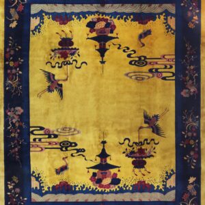 Gold and navy rug featuring stylized cranes, clouds, and floral borders, laid on light wooden floors.
