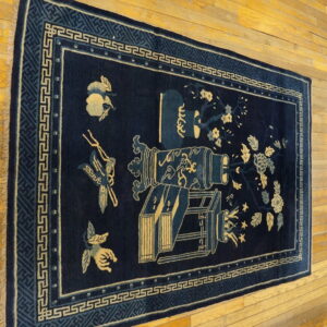 Dark blue runner rug with pale yellow floral and lantern designs rests on golden hardwood flooring.