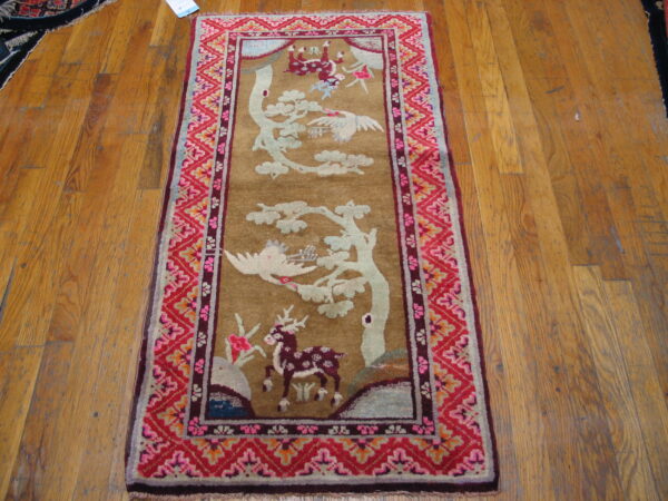 A brown, low-pile runner featuring white cranes and a maroon deer, surrounded by a vivid red and pink border.