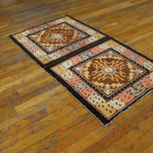 Brown and tan geometric runner rug with pink accents lies diagonally on distressed hardwood flooring.