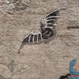 Beige high-pile rug detail showing a gray wing with white stripes, red dots, and striped blue and coral shapes.