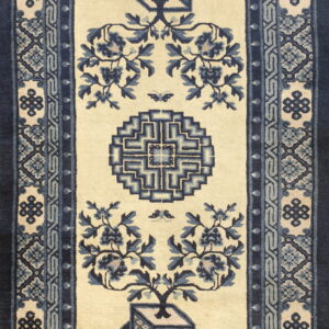Ivory runner rug featuring blue potted plant motifs, a circular emblem, and wide geometric borders.