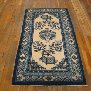 Blue and cream runner rug with stylized floral and geometric designs on a light brown plank wood floor.