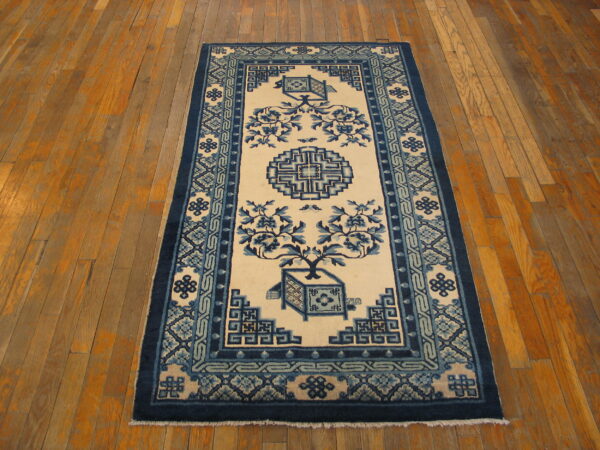 Blue and cream runner rug with stylized floral and geometric designs on a light brown plank wood floor.
