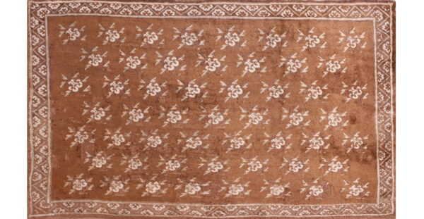 Brown rug featuring an allover pattern of off-white flowers and a detailed floral border.