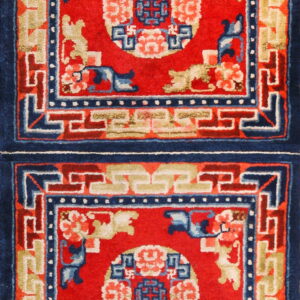 Vertical red rug runner with stacked rectangular panels, indigo borders, and tan geometric accents.