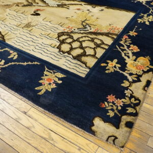 Navy and beige scenic rug with detailed wildlife and floral elements on natural wood flooring.