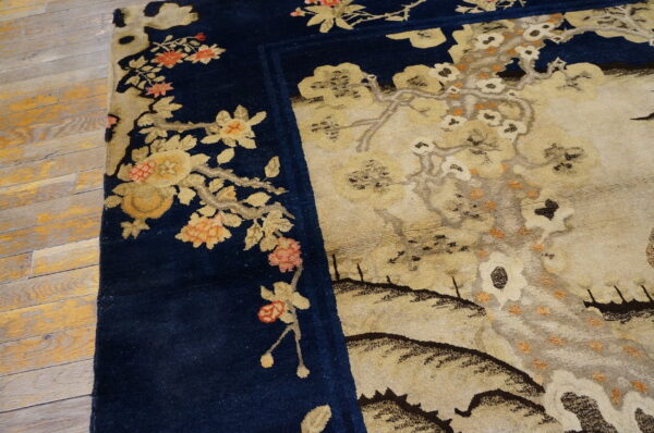 Navy blue border with coral and gold florals surrounds a detailed beige scenic field on rustic wood.