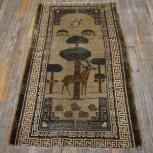 Tan runner rug with a brown deer and trees motif bordered by geometric patterns on weathered wooden planks.