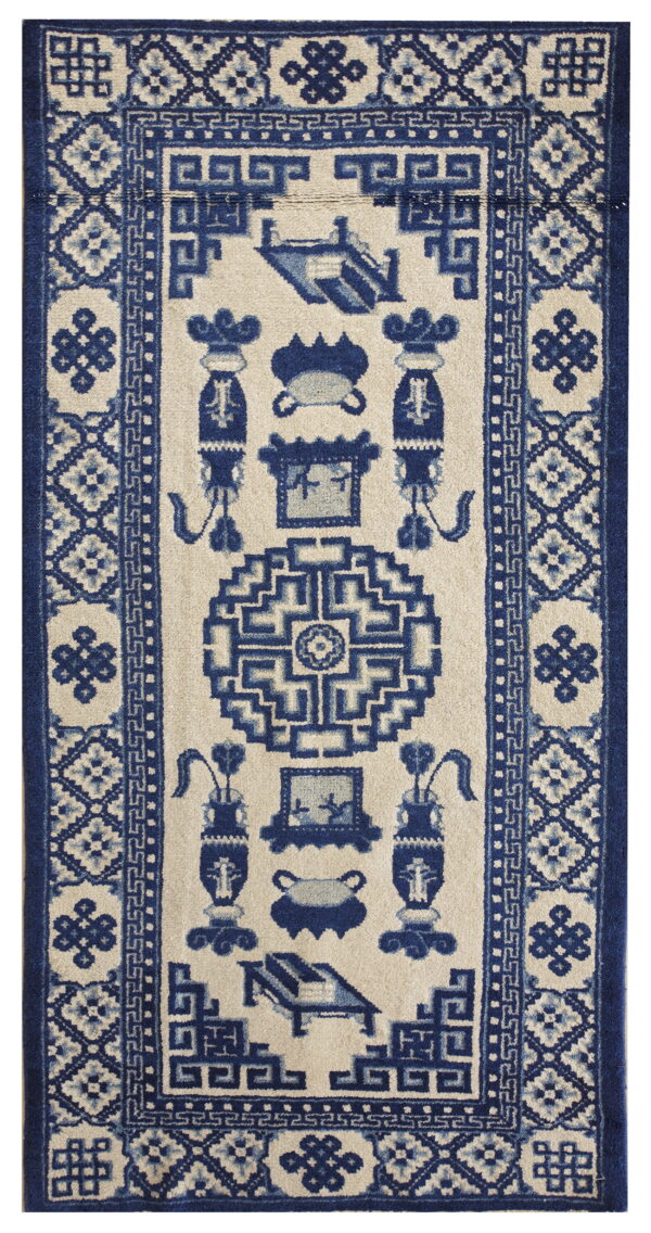 Beige runner rug with dense navy blue geometric borders and stylized, symmetrical central motifs.