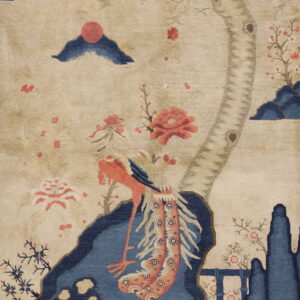Detail of a rug with a scenic motif: coral bird, blue water, tan tree, and dark blue clouds.