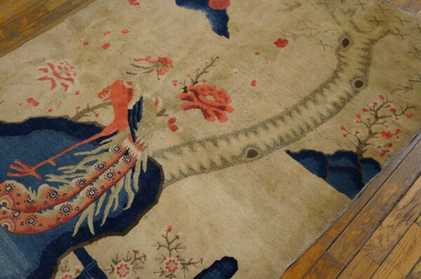 Small scenic pictorial antique chinese bird design baotou area rug 5 High-pile tan rug with a detailed pictorial scene featuring a large red bird and blue areas.