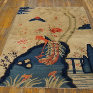 Beige scenic rug with blue landscape elements and coral flowers resting on wide plank wood flooring.